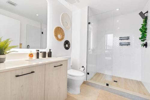 La salle de bains blanche est pourvue d'une douche et de toilettes. dans l'établissement Wynwood Luxury Apt, à Miami