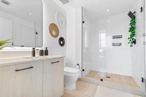 a white bathroom with a toilet and a shower at Wynwood Luxury Penthouse in Miami