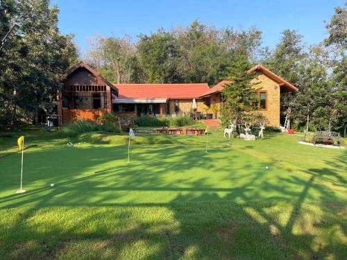una casa con un putting green delante de ella en Bella Vista Khao yai en Ban Muak Lek Nai