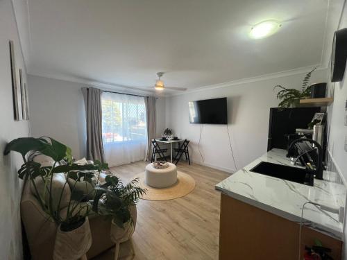 a kitchen and living room with a counter and a table at Sussex Gem - Cozy apartment in the heart of Sussex in Sussex inlet