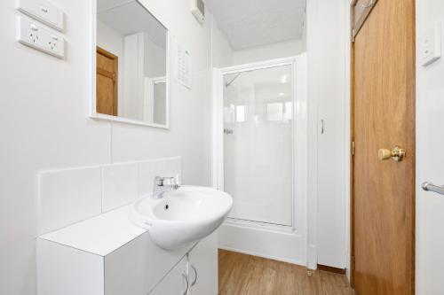 uma casa de banho branca com um lavatório e um espelho em Eureka Stockade Holiday Park em Ballarat