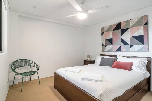 ein Schlafzimmer mit einem Bett und einem Stuhl in der Unterkunft 'The Abstract at Kingsford' Spacious and Sunny Stay in Sydney