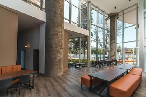 Cette grande chambre dispose de tables, de chaises et de grandes fenêtres. dans l'établissement Torre Golden 8Pax By Inside, à Mendoza
