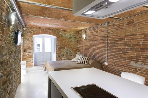 a room with two beds and a brick wall at Loft n°18 in Arezzo