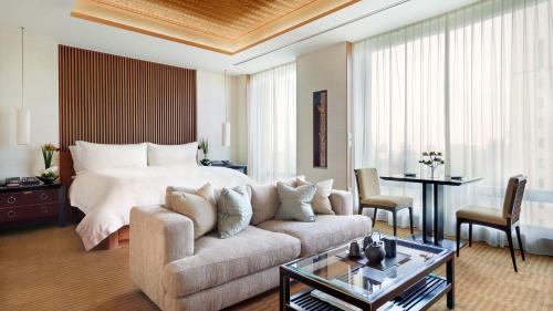 a bedroom with a bed and a couch and a table at The Peninsula Tokyo in Tokyo