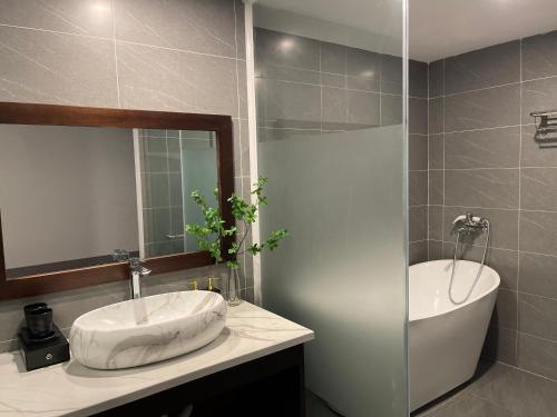 ein Badezimmer mit einem Waschbecken, einem Spiegel und einer Badewanne in der Unterkunft Vedana resort in Chi Phương