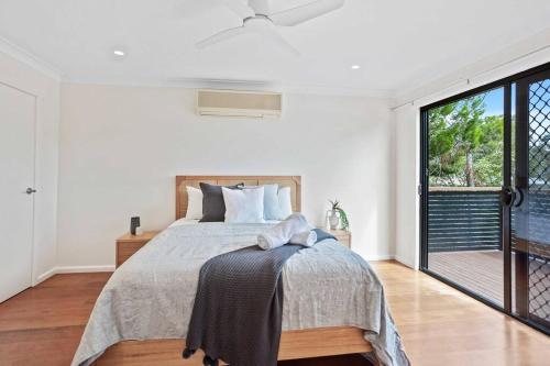 a bedroom with a bed and a large window at Lakefront Living in Burleigh in Gold Coast