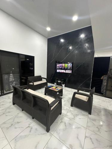 a living room with black furniture and a flat screen tv at Villa lili, Carmen de Apicala condominio San Simon in Carmen de Apicalá