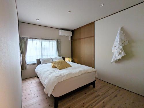 um quarto com uma cama com uma árvore de Natal na parede em Cobaco Ohori - Renovation Vacation rental em Fukuoka