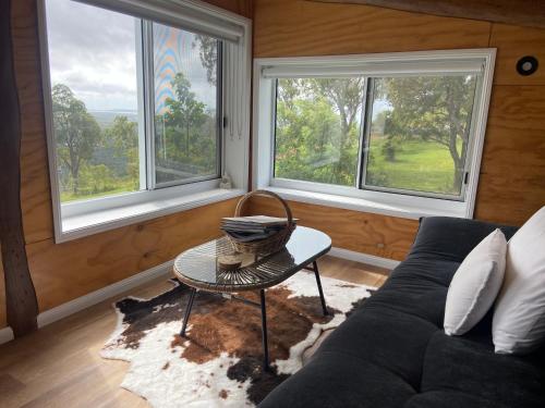 a living room with a couch and two windows at The Lookout Chalet luxury getaway retreat in Farnborough