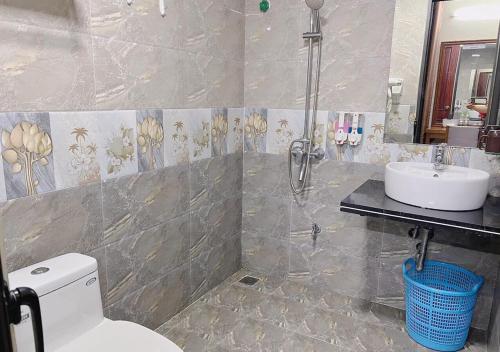 a bathroom with a shower and a toilet and a sink at Thu Ha Hotel in Uông Bí