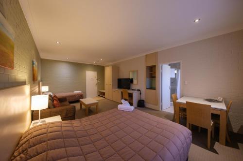 a hotel room with a bed and a desk at Imperial Motel in Bowral