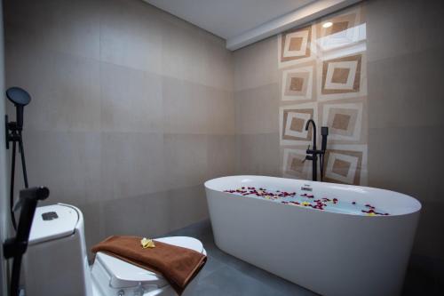 a bathroom with a white tub with confetti on it at Griya D'Carik in Perean