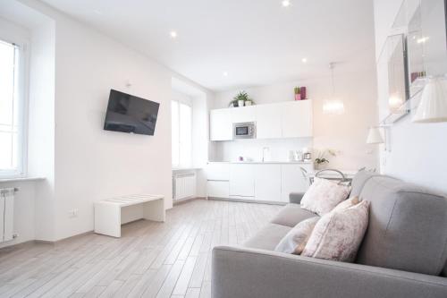 a white living room with a couch and a tv at Cinque Terre Bridge in La Spezia