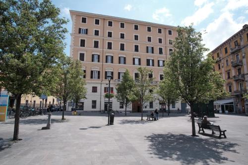 a large building with people sitting on a bench in a courtyard at Cinque Terre Bridge in La Spezia