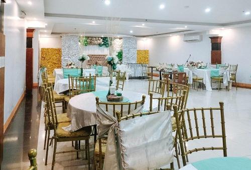 a banquet hall with tables and chairs with blue and white at RedDoorz at Nick Hotel Isabela 