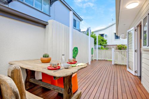 a patio with a wooden table and chairs on a deck at Cathy's Cottage in Cairns