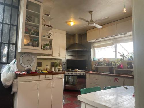 a kitchen with white cabinets and a counter top at Amplia Habitacion en San Telmo in Buenos Aires