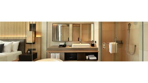 a bathroom with a sink and a shower with a mirror at Royal Tulip Gunung Geulis Resort and Golf in Bogor