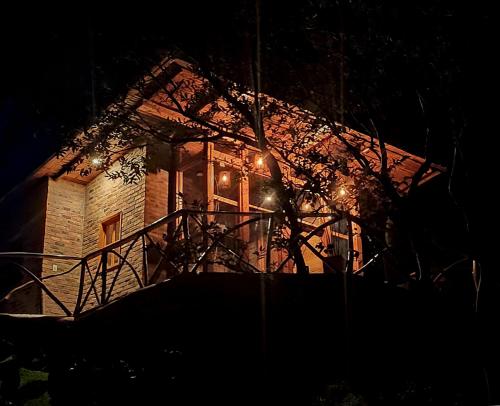 a house lit up at night with lights at BAUMHAUS Cabañas rusticas con jacuzzi privado in San Francisco