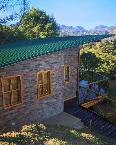 a small brick building with a green roof at BAUMHAUS Cabañas rusticas con jacuzzi privado in San Francisco