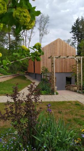 a garden with a building in the background at Gîte Le Charme d'Argent in Charmois-devant-Bruyères