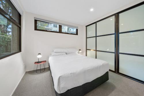 een slaapkamer met een wit bed en grote ramen bij Spacious 3-Bed Home with Alfresco Dining Patio in Canberra