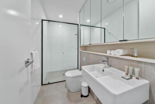 een badkamer met een wastafel, een toilet en een spiegel bij Spacious 3-Bed Home with Alfresco Dining Patio in Canberra