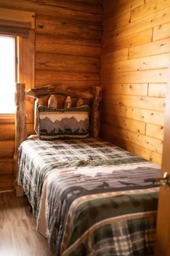 a bedroom with a bed in a log cabin at the log cabin in Deerwood