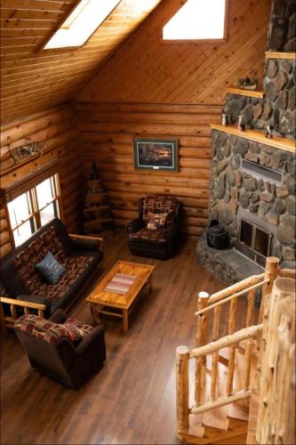 a living room with a fireplace in a log cabin at the log cabin in Deerwood