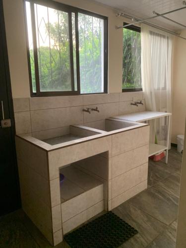 een badkamer met 2 wastafels en 2 ramen bij El Tambor B1 in Alajuela