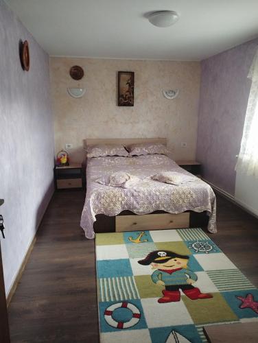een slaapkamer met een bed en een tapijt op de vloer bij Vila la 4 Turturici in Năvodari