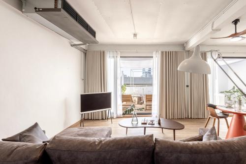 a living room with a couch and a table at The Lair Bangkok - 3mins walk to ICON SIAM in Bangkok