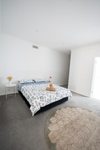 a bedroom with a bed with a teddy bear on it at Spacious & Modern 4 Bedrooms in Tuggeranong