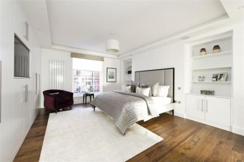 Habitación blanca con cama y escritorio en Large Super Penthouse Park Lane Opposite Hyde Park Sleeps 12, en Londres