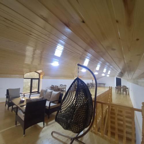a living room with a swing hanging from the ceiling at Lahij Rashad Ismayilov Hotel in Lahıc