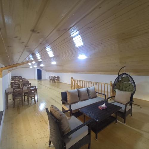 a large room with chairs and tables and a dining room at Lahij Rashad Ismayilov Hotel in Lahıc