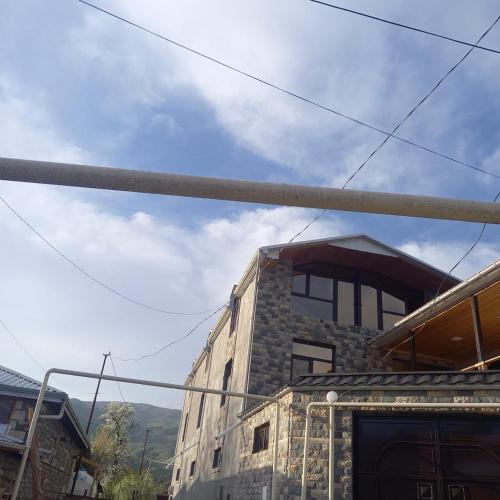 a building with a pole in front of it at Lahij Rashad Ismayilov Hotel in Lahıc