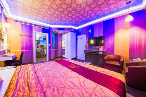 a bedroom with a large bed and purple walls at Wen Sha Bao Motel-Xinying in Xinying