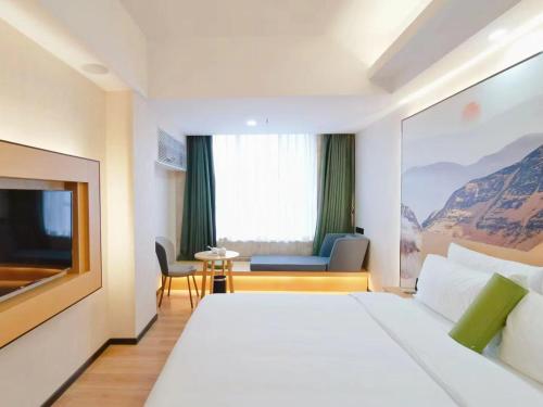 una camera d'albergo con un grande letto e un tavolo di Connar Hotel - Shenzhen Shawei a Shenzhen
