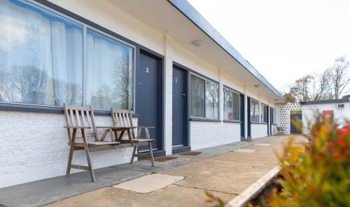 a wooden chair sitting on the side of a building at Australian Hotel Motel Yass in Yass