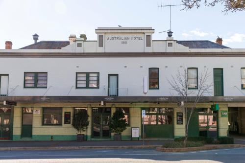 an old white building on the corner of a street at Australian Hotel Motel Yass in Yass