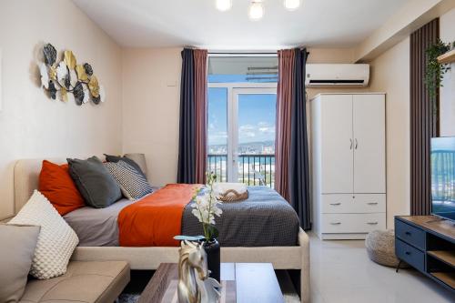 Un dormitorio con una cama y una ventana grande. en Nomads' Haven a budget friendly Zen Studio, en Lapu Lapu City
