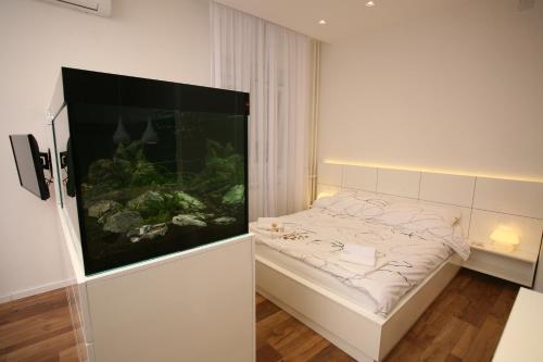 a bed with a fish tank in a room at City Place Apartments in Belgrade