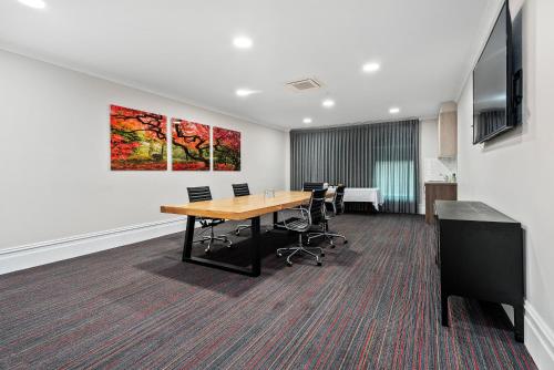 a conference room with a wooden table and chairs at Quality Hotel Parklake Shepparton in Shepparton