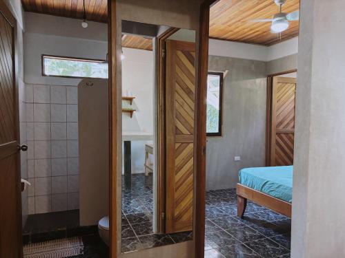 a room with a bed and a door leading to a bedroom at Don Jon*s in Santa Teresa Beach