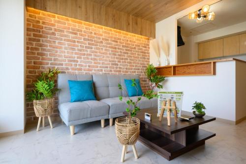 a living room with a couch and a brick wall at Nakajima Park Hotel AMS tower Nakajima 18F 1801 in Sapporo
