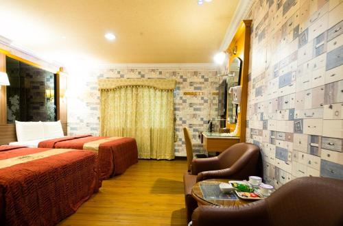 a hotel room with two beds and a table at Wen Sha Bao Motel-Xinying in Xinying