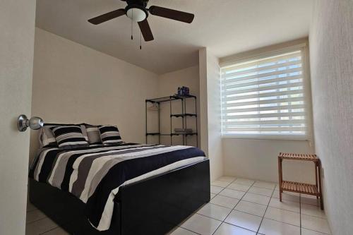um quarto com uma cama em preto e branco e uma ventoinha de tecto em Allissons House Cómoda Casa con Alberca y Quiosco em Emiliano Zapata
