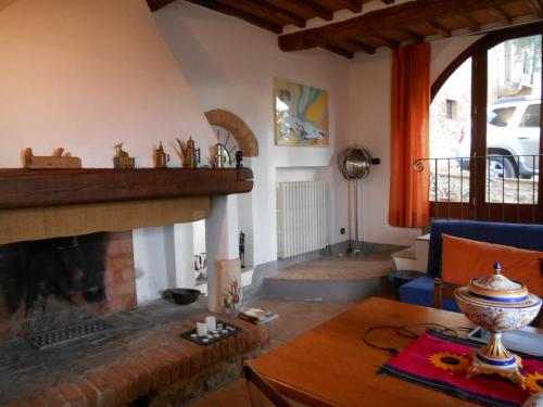 a living room with a fireplace and a table at Podere Sammonti in Monteriggioni